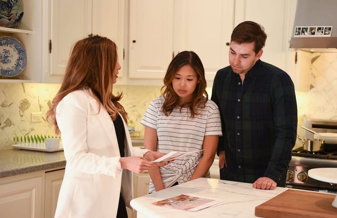 young homebuyer couple inside home kitchen with realtor-1